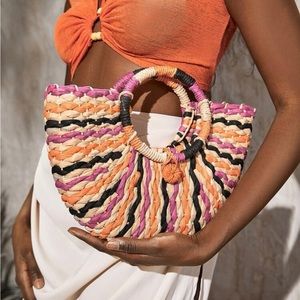 Color block straw bag with orange, magenta, and tan detailing.